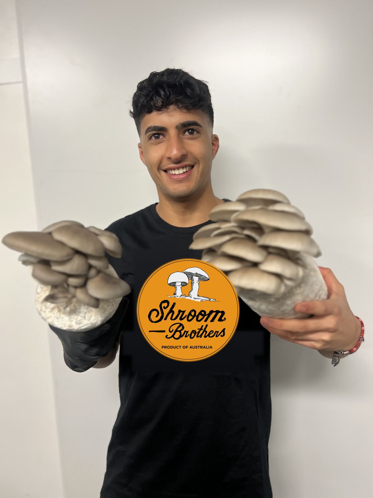 Grower holding two colonised oyster blocks